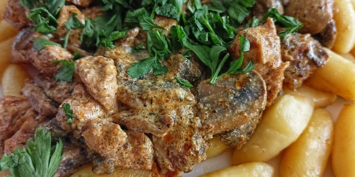 Kopytka do jedzenia z sosem, posypane pietruszką